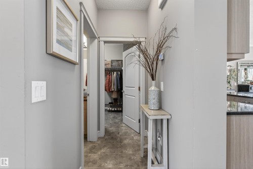 Hallway featuring neutral gray wall paint, textured ceiling, durable tiled flooring, and white trim work - 2313 Sparrow Crescent, Edmonton, AB - Indoor Photo Showing Other Room