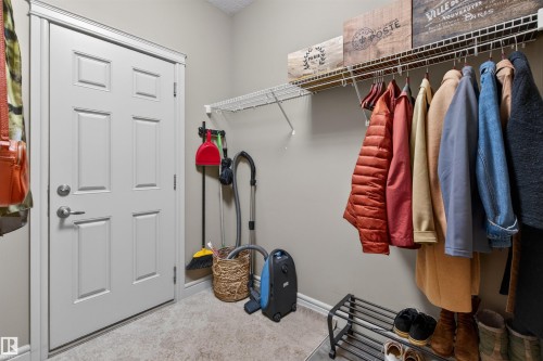Entryway featuring a paneled door with brushed nickel hardware, light-toned flooring, wire shelving, and neutral wall paint - 2313 Sparrow Crescent, Edmonton, AB - Indoor With Storage