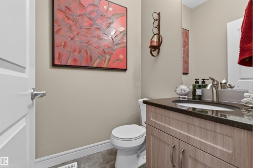 Bathroom featuring a vanity with a dark countertop, an undermount sink, and a brushed nickel faucet - 2313 Sparrow Crescent, Edmonton, AB - Indoor Photo Showing Bathroom