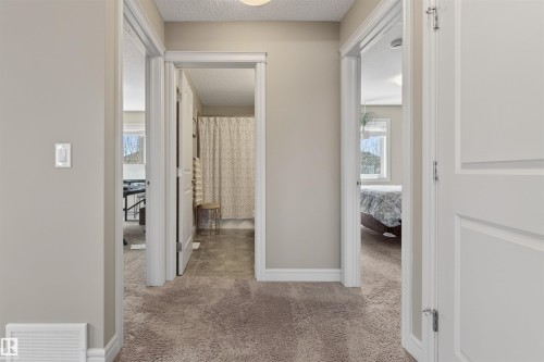Hallway featuring neutral wall paint, white trim, and textured carpeting - 2313 Sparrow Crescent, Edmonton, AB - Indoor Photo Showing Other Room