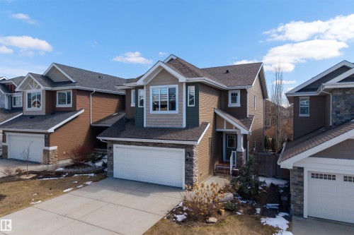 Two-story residence featuring a brown and green facade with stone accents, a prominent front-facing gable, and a two-car garage - 2313 Sparrow Crescent, Edmonton, AB - Outdoor With Facade