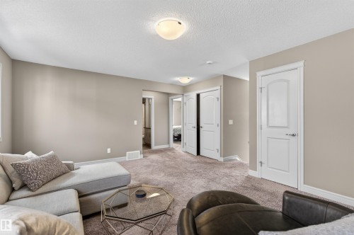 Spacious carpeted room featuring neutral wall tones, white trim, and recessed lighting - 2313 Sparrow Crescent, Edmonton, AB - Indoor