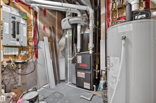 Utility area featuring a water heater, furnace system, and electrical panel - 2313 Sparrow Crescent, Edmonton, AB - Indoor Photo Showing Basement