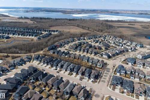Aerial perspective of a residential community featuring diverse housing styles, paved streets, and mature trees - 2313 Sparrow Crescent, Edmonton, AB - Outdoor With View