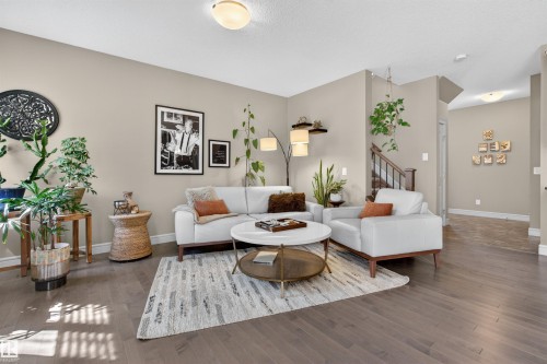 Spacious living area featuring expansive wood-finish flooring, neutral wall tones, and recessed ceiling lighting - 2313 Sparrow Crescent, Edmonton, AB - Indoor Photo Showing Living Room