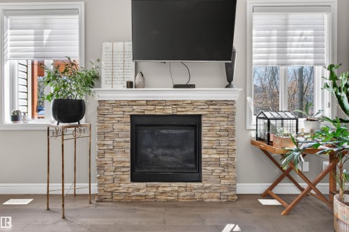 Stacked stone fireplace with a white mantel and dark firebox - 2313 Sparrow Crescent, Edmonton, AB - Indoor Photo Showing Living Room With Fireplace