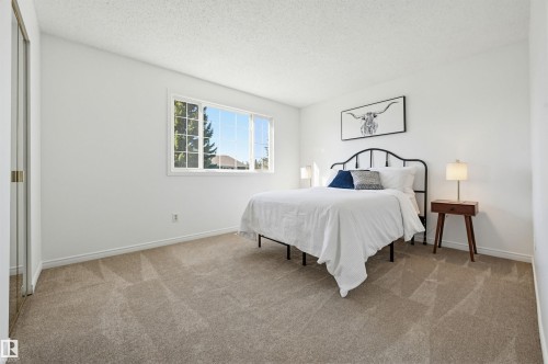Bedroom featuring neutral-toned carpet, white walls, and a large window with white trim - 8043 178 Street, Edmonton, AB - Indoor Photo Showing Bedroom