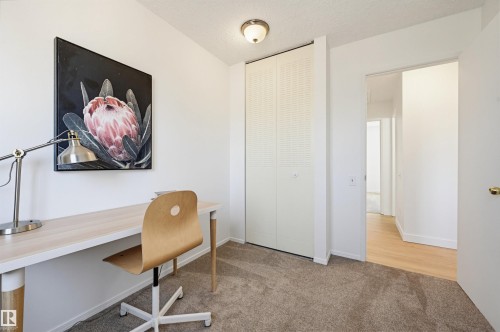Carpeted room with white walls, a built-in closet with louvered bi-fold doors, and a flush-mount ceiling light fixture - 8043 178 Street, Edmonton, AB - Indoor