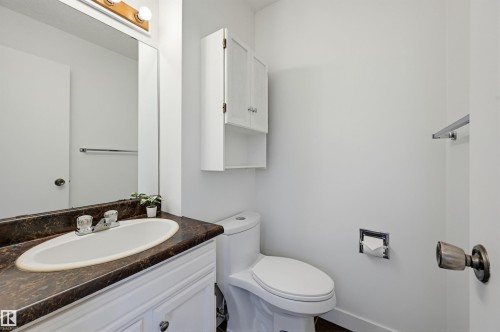 Bathroom featuring a white vanity with a dark countertop and an oval undermount sink - 8043 178 Street, Edmonton, AB - Indoor Photo Showing Bathroom
