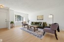 Bright living space featuring expansive wood-finish flooring, a large multi-pane window, and recessed lighting - 8043 178 Street, Edmonton, AB  - Indoor Photo Showing Living Room 