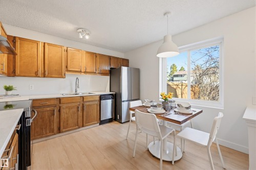 Kitchen featuring wood cabinetry, light countertops, and light wood-finish flooring - 8043 178 Street, Edmonton, AB - Indoor