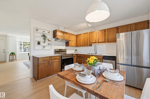 Kitchen featuring wood cabinetry, light countertops, and stainless steel appliances - 8043 178 Street, Edmonton, AB - Indoor