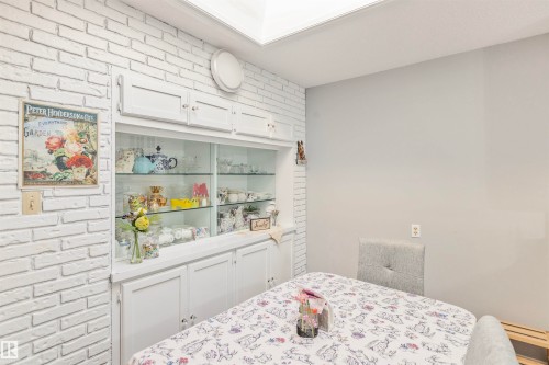Built-in white cabinetry featuring glass display shelves and lower storage - 1619 Knottwood Road N, Edmonton, AB - Indoor Photo Showing Bedroom