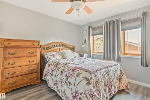 Room featuring light gray walls, wood-finish flooring, and a ceiling fan with integrated lighting - 1619 Knottwood Road N, Edmonton, AB - Indoor Photo Showing Bedroom