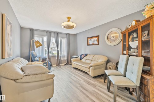 Spacious living area featuring light gray walls and wood-finish flooring - 1619 Knottwood Road N, Edmonton, AB - Indoor Photo Showing Living Room