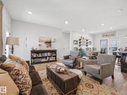 Spacious living area featuring recessed lighting, light wood-finish flooring, and white walls - 