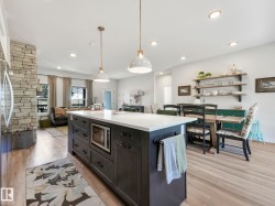 Spacious kitchen island with a white countertop and built-in microwave - 