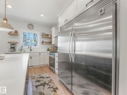 Stainless steel refrigerator with double doors and upper cabinetry - 