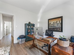 Room with light wood-finish flooring, white walls, and a built-in blue shelving unit - 