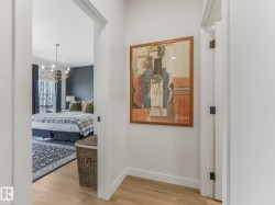 Hallway featuring light wood-finish flooring and white baseboards - 