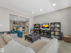 Spacious living area featuring light gray wall paint and recessed ceiling lighting - 