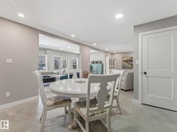 Recessed lighting illuminates the open-concept living area with light gray walls and durable concrete flooring - 
