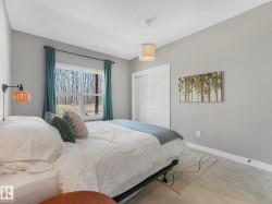 Spacious room featuring a large window, sliding closet doors, concrete flooring, and a ceiling-mounted light fixture - 