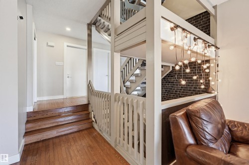 Hardwood flooring throughout, showcasing a multi-level staircase with painted wood railings - 139 Wolf Willow Crescent, Edmonton, AB - Indoor Photo Showing Other Room