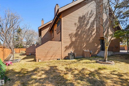 Brown horizontal siding exterior with a pitched roofline, featuring a fenced backyard with established trees - 139 Wolf Willow Crescent, Edmonton, AB - Outdoor