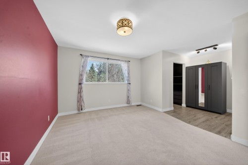 Spacious room featuring a large window, neutral carpeting, and a contrasting accent wall - 1767 61 Street, Edmonton, AB - Indoor Photo Showing Other Room