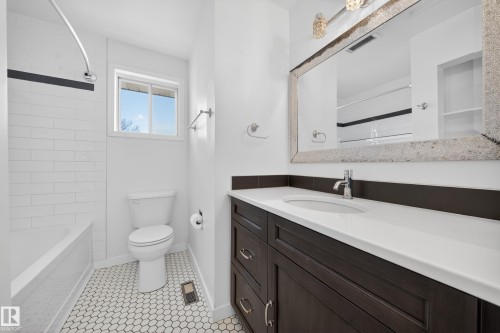 Bathroom with a dark wood-finish vanity, white countertop, and integrated sink - 1767 61 Street, Edmonton, AB - Indoor Photo Showing Bathroom