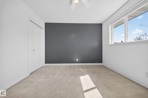Room featuring light neutral carpeting, a dark accent wall, and white trim - 1767 61 Street, Edmonton, AB - Indoor Photo Showing Other Room