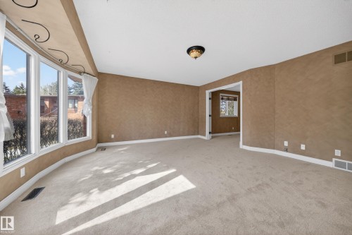 Carpeted living area featuring a curved wall of large windows - 1767 61 Street, Edmonton, AB - Indoor Photo Showing Other Room