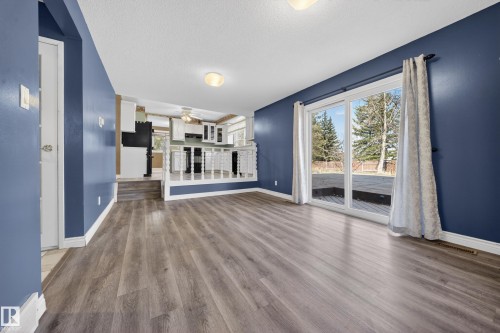 Spacious room featuring wood-finish flooring, a sliding glass door to a deck, and recessed lighting - 1767 61 Street, Edmonton, AB - Indoor Photo Showing Other Room