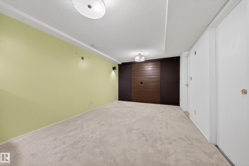 Spacious room featuring light green walls, light-colored carpet, and white trim - 1767 61 Street, Edmonton, AB - Indoor Photo Showing Other Room