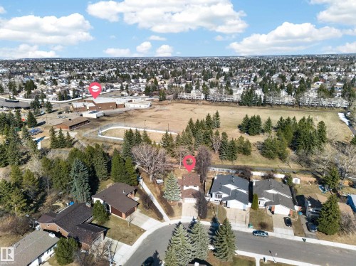 Aerial perspective showcasing a residential neighborhood with detached homes, mature trees, and a clear sky - 1767 61 Street, Edmonton, AB - Outdoor With View