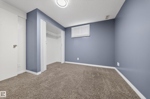 Room featuring neutral carpet flooring, blue painted walls, and white trim - 1767 61 Street, Edmonton, AB - Indoor Photo Showing Other Room
