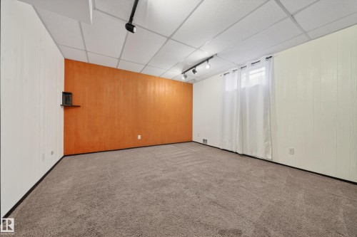 Carpeted room featuring an accent wall, track lighting, and a drop ceiling - 1767 61 Street, Edmonton, AB - Indoor Photo Showing Other Room