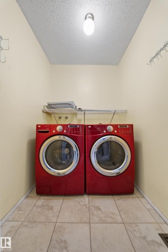 Dedicated laundry area featuring ceramic tile flooring, a wall-mounted utility shelf, and ceiling-mounted lighting - 1767 61 Street, Edmonton, AB - Indoor Photo Showing Laundry Room