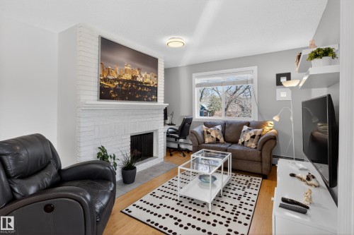 with operational Fireplace - 211 10838 108 Street, Edmonton, AB - Indoor Photo Showing Living Room With Fireplace