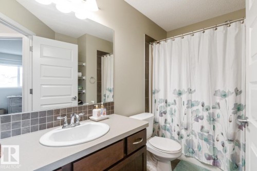 Bathroom featuring a single vanity with an oval basin, chrome faucet, and a light-toned countertop - 5127 1A Avenue, Edmonton, AB - Indoor Photo Showing Bathroom