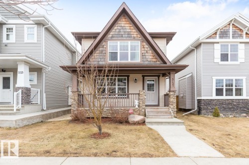 Two-story property featuring a prominent gable roofline with shake siding accents, horizontal siding, and stone veneer detailing - 5127 1A Avenue, Edmonton, AB - Outdoor With Deck Patio Veranda With Facade