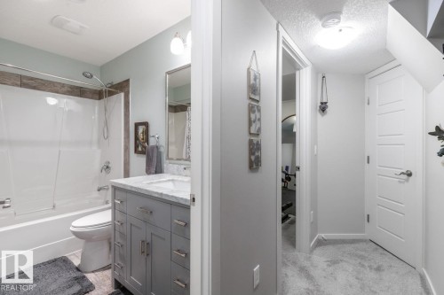Bathroom featuring a white tub/shower combination with a tiled surround - 5127 1A Avenue, Edmonton, AB - Indoor Photo Showing Bathroom