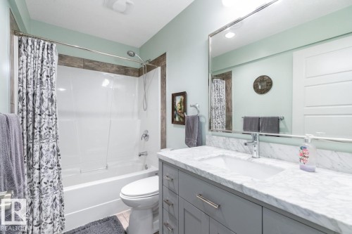 Bathroom featuring a gray vanity with an integrated rectangular sink, a marble-finish countertop, and chrome fixtures - 5127 1A Avenue, Edmonton, AB - Indoor Photo Showing Bathroom