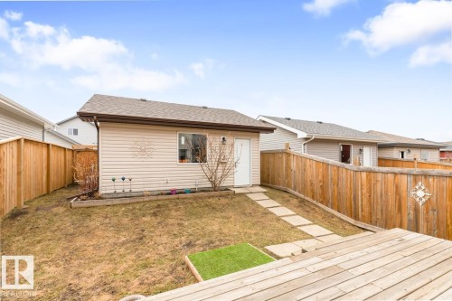 Expansive backyard featuring a wood deck, stone pathway, and full privacy fencing - 5127 1A Avenue, Edmonton, AB - Outdoor With Deck Patio Veranda With Exterior