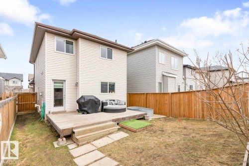 Rear exterior with a wood-finish deck and concrete patio pavers - 5127 1A Avenue, Edmonton, AB - Outdoor With Deck Patio Veranda With Exterior