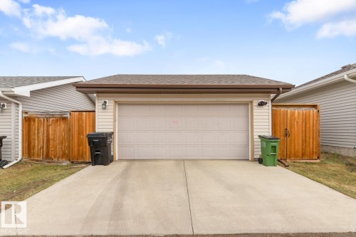 Attached two-car garage with a concrete driveway, complemented by light-colored siding and a brown shingled roof - 5127 1A Avenue, Edmonton, AB - Outdoor With Exterior