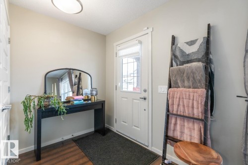 Entryway featuring wood-finish flooring, a contemporary ceiling light fixture, and a paneled entry door with frosted glass detailing - 5127 1A Avenue, Edmonton, AB - Indoor Photo Showing Other Room
