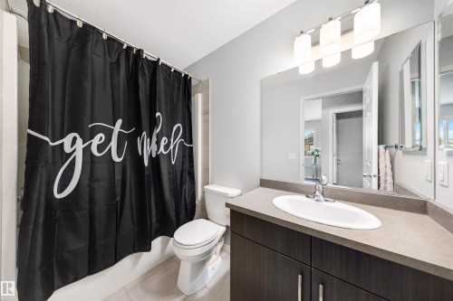 Bathroom featuring a single vanity with a dark wood-finish cabinet, integrated sink, and chrome faucet - 2504 Coughlan Road, Edmonton, AB - Indoor Photo Showing Bathroom
