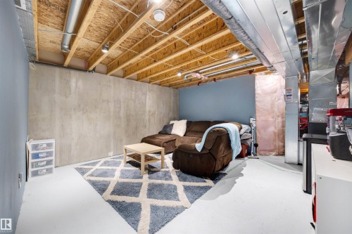 Unfinished lower level featuring exposed ceiling joists, concrete walls, painted concrete flooring, and recessed lighting - 2504 Coughlan Road, Edmonton, AB - Indoor Photo Showing Basement